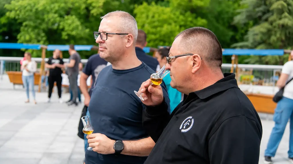 Muškarci procenjuju miris rakije tokom degustacije na otvorenom